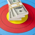 A stack of dollar bills on top of a bullseye