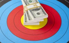 A stack of dollar bills on top of a bullseye