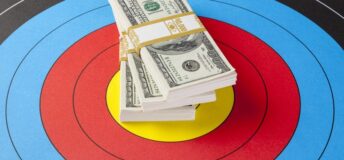 A stack of dollar bills on top of a bullseye