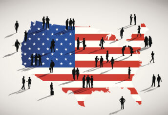 Silhouettes of people standing on the US flag.