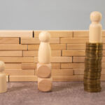 Miniature people standing on high and low. the gap between rich and poor according to an index of inequality.