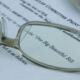 Glasses magnify text noting this is the "One Big Beautiful Bill."
