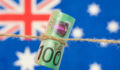 In brief: Australian Ethical and CEFC partner for impact Close up of an Australian one hundred dollar bill tied in string. Australian flag in background.