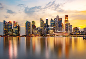 Temasek to scale infra exposure, cites energy transition opportunities Moody Sky at Sunset with Reflection in Marina Bay, Long Exposure to Blur Water