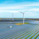 Photo of a windmill in a field with windmills in the back.